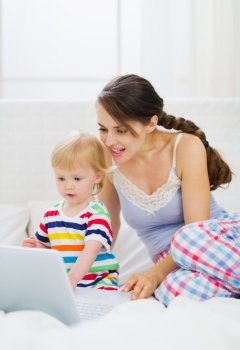 Modern young mother and baby using laptop