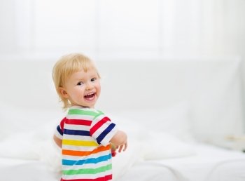 Portrait of smiling baby in bedroom