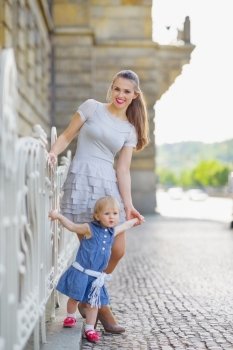 Full length portrait of mother and baby in city