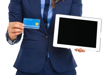 Closeup on business woman showing credit card and tablet pc blank screen