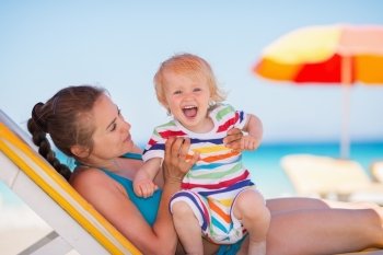 Portrait of excited baby with mother on beach