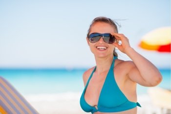 Portrait of smiling woman in sunglasses on beach
