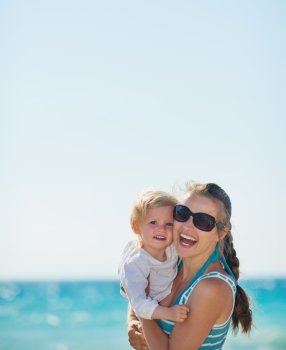 Portrait of happy mother and baby on beach