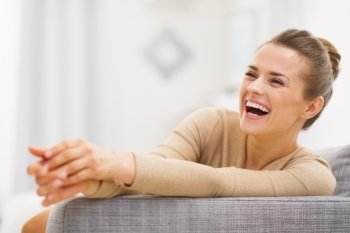 Smiling young woman sitting on sofa