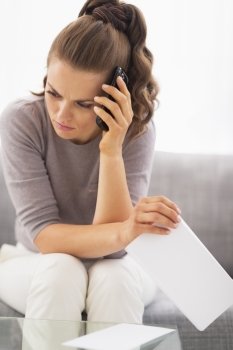 Frustrated young woman with letter and cell phone