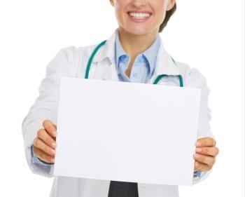 Closeup on blank paper sheet in hand of smiling doctor woman