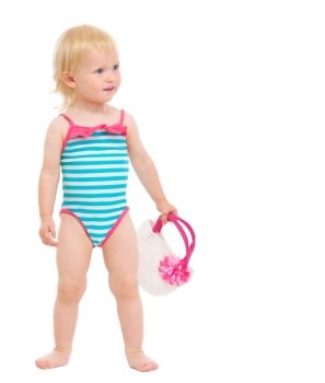 Cute baby in swimsuit with handbag looking on copy space