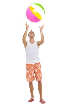 Full length portrait of young man playing with beach ball