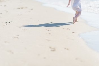 Closeup on baby running on sea shore