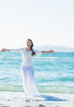 Happy young woman rejoicing on sea shore
