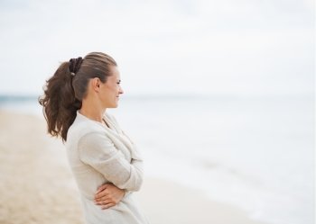 Young woman in sweater on beach looking into distance