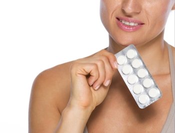 Closeup on young woman with pack of pills