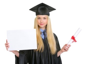 Young woman in graduation gown with diploma showing blank billboard