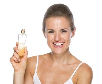 Smiling young woman showing perfume bottle