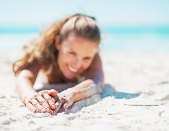 Closeup on happy young woman in swimsuit relaxing on beach