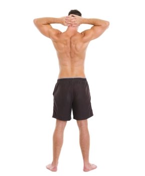 Sports man showing muscular body. Rear view