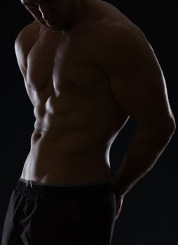 Closeup on male athlete showing muscular body on black