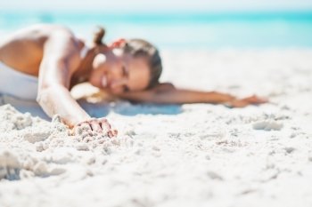 Closeup on young woman in swimsuit laying on beach