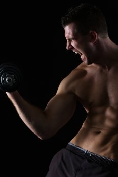 Angry muscular athlete workout biceps on black