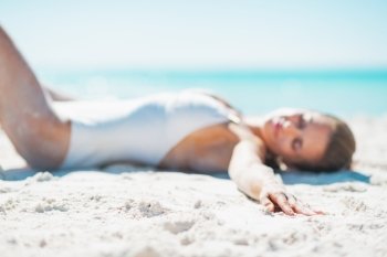 Closeup on relaxed young woman in swimsuit sunbathing on sandy beach