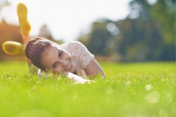 Smiling young woman laying on grass