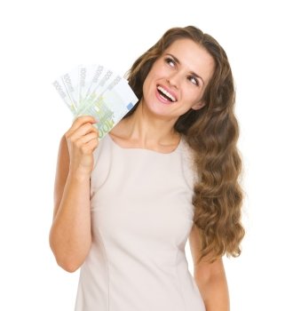 Happy young woman with euros looking up on copy space