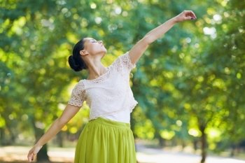 Young woman dancing in park
