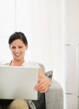 Happy young woman working on laptop