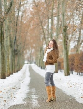 Happy young woman walking in winter park