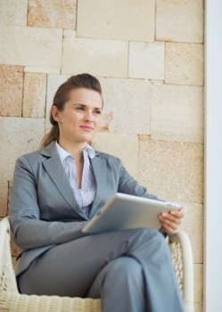 Thoughtful business woman with tablet pc sitting on terrace