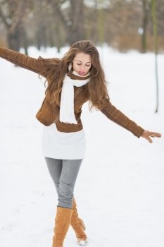 Happy young woman having fun in winter outdoors