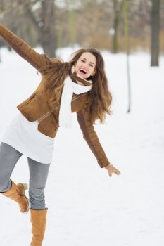 Happy young woman having fun in winter park