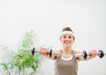 Young sport woman making exercise with dumbbells