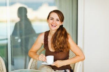 Happy woman enjoying coffee on terrace
