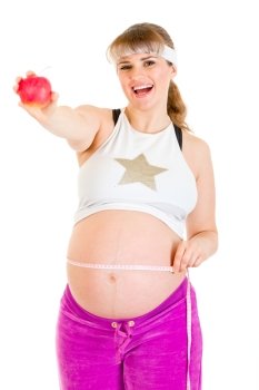Smiling beautiful pregnant woman measuring her belly and holding apple isolated on white
