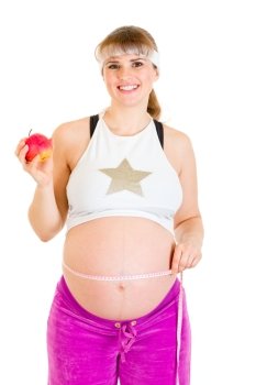 Smiling beautiful pregnant woman measuring her belly and holding apple isolated on white
