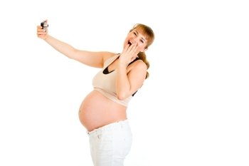 Laughing pregnant woman photographing herself isolated on white
