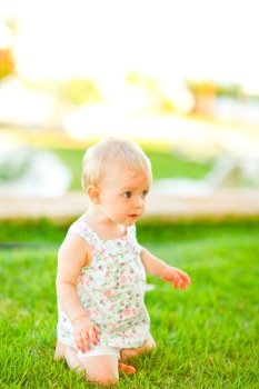 Interested baby playing on grass
