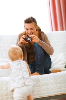 Modern mother making photos of baby at home
