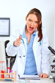 Angry medical doctor woman shouting and pointing on you
