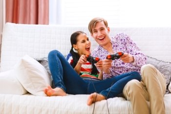 Young happy couple playing console

