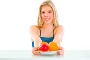 Cheerful lovely young girl sitting at table with plate of fruits
