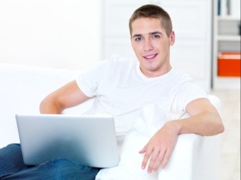 successful young man with laptop at home