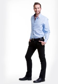 Portrait of smiling happy man in blue shirt and black pants - isolated on white.
