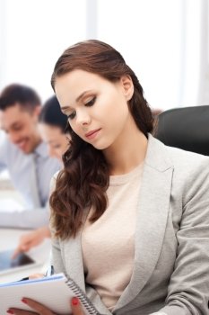 business concept - attractive businesswoman taking notes in office