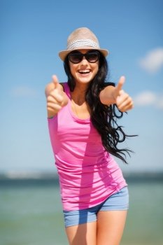 summer holidays and vacation - girl showing thumbs up on the beach