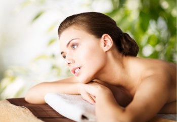 beauty and spa concept - woman in spa lying on the massage desk