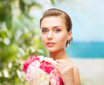 beauty and jewelry concept - woman wearing earrings, ring and holding flowers