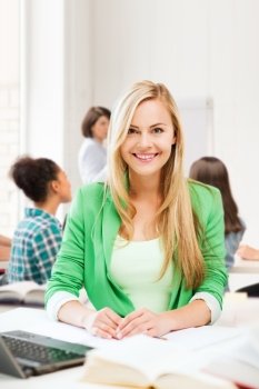 education and technology concept - smiling student girl with laptop at school