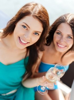 summer holidays and vacation - girls with champagne glasses on boat or yacht